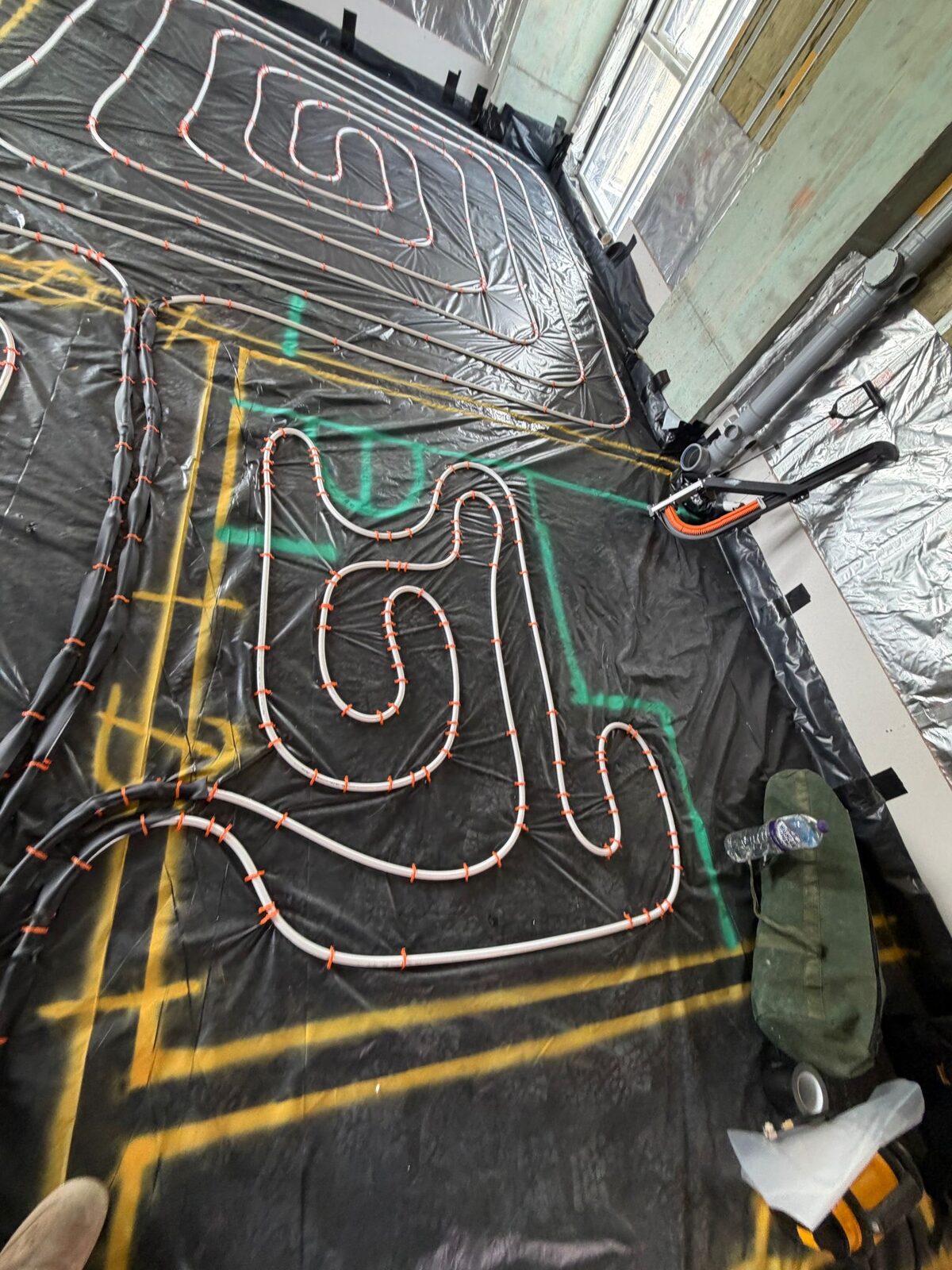 Wet underfloor heating pipe loops laid to a marked design on a London installation