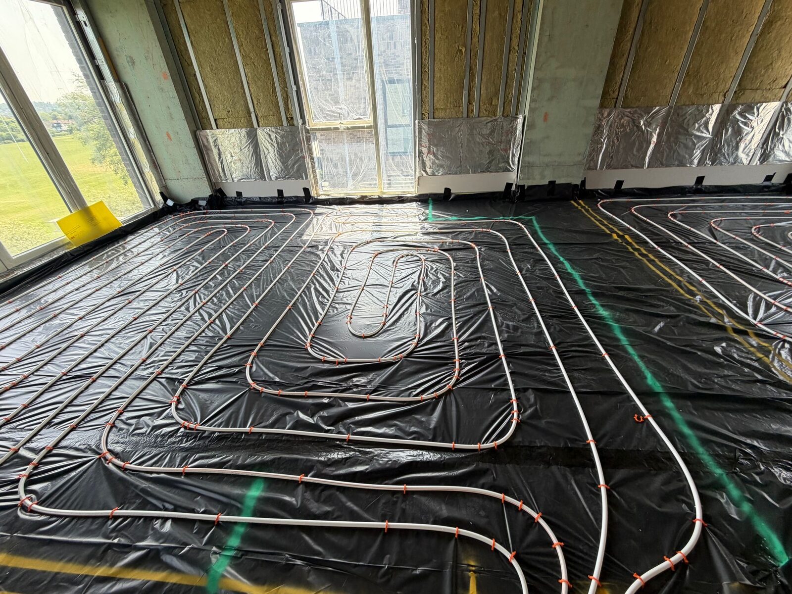 Whole-room wet underfloor heating pipe loops laid across a London property